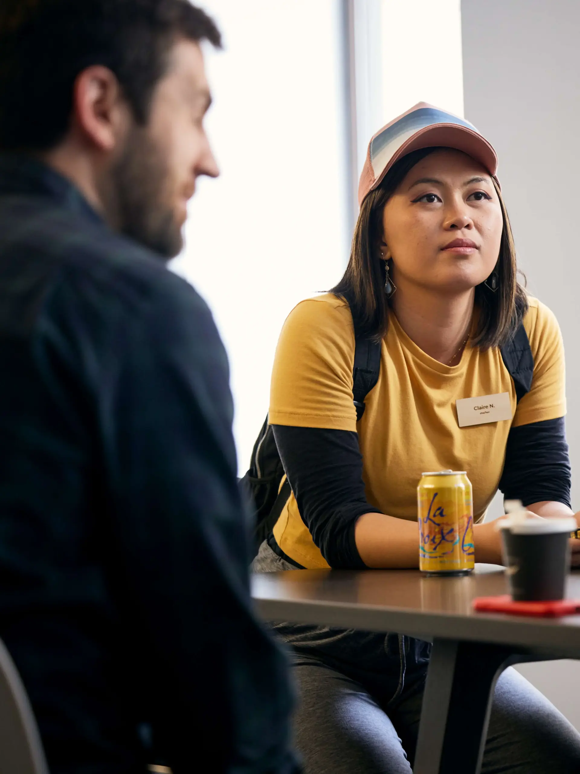Woman listening to coworkers while sitting at a table