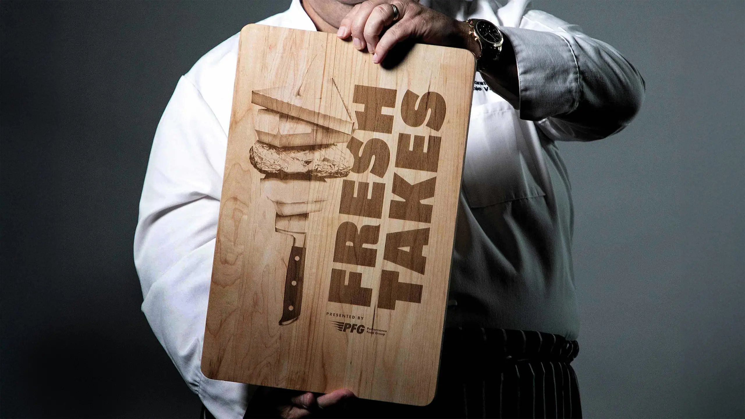 Wooden cutting board with a branded image of the FreshTakes by Performance Food Group branding