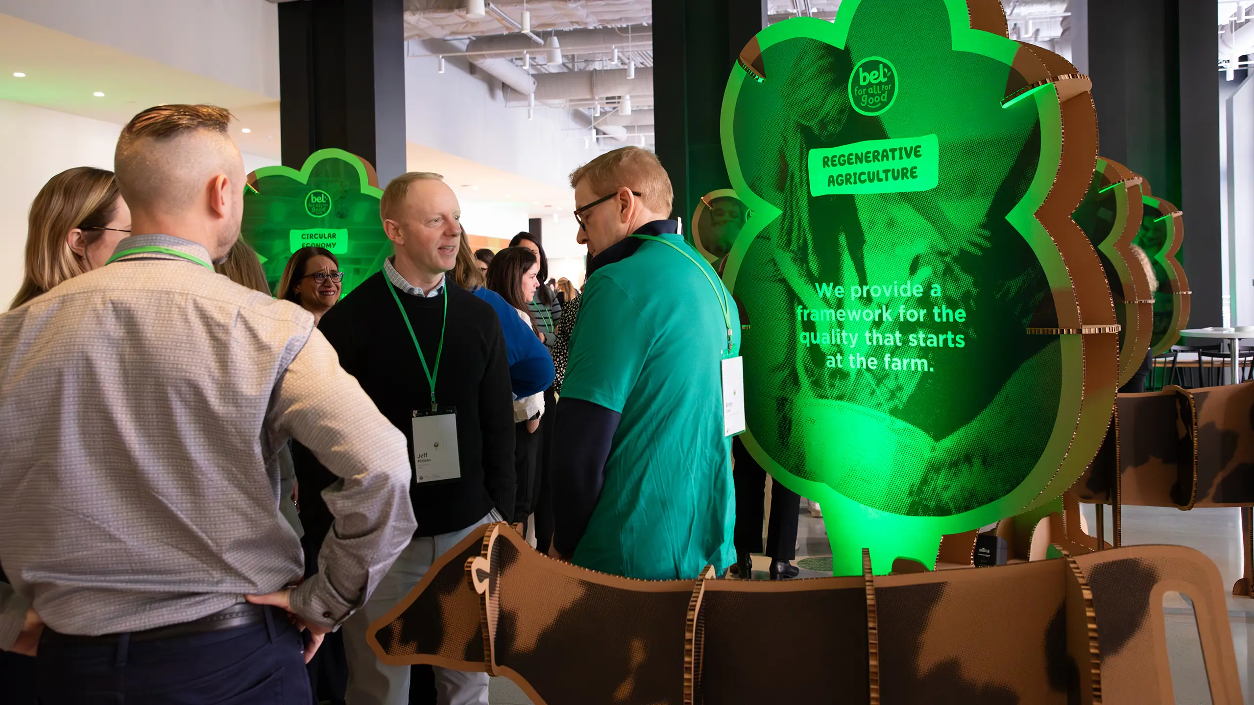 A group of people in the lobby of the ‘All In 2025’ with experiential trees and cows