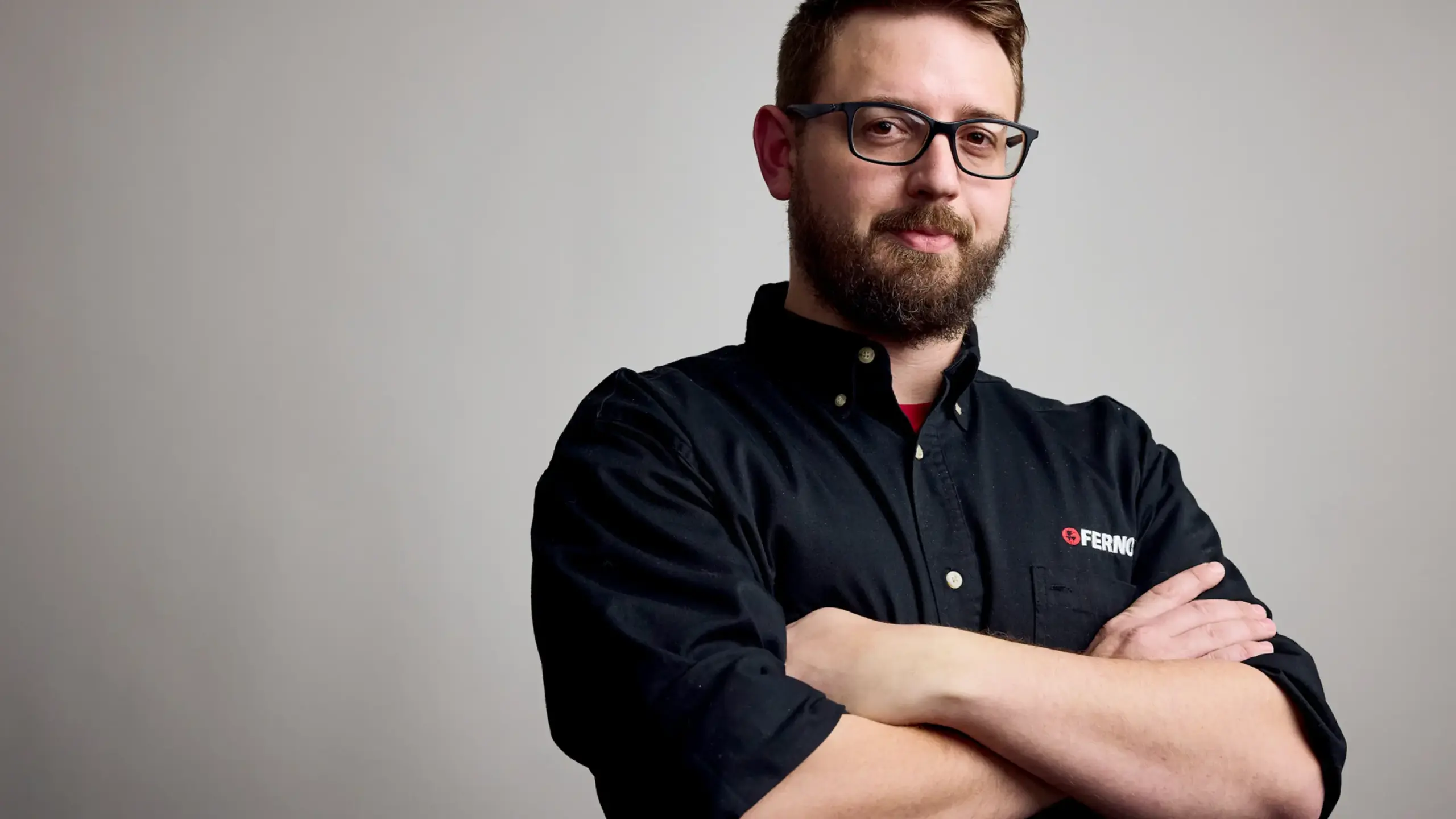 Ferno employee standing with arms folded confidently and smiling
