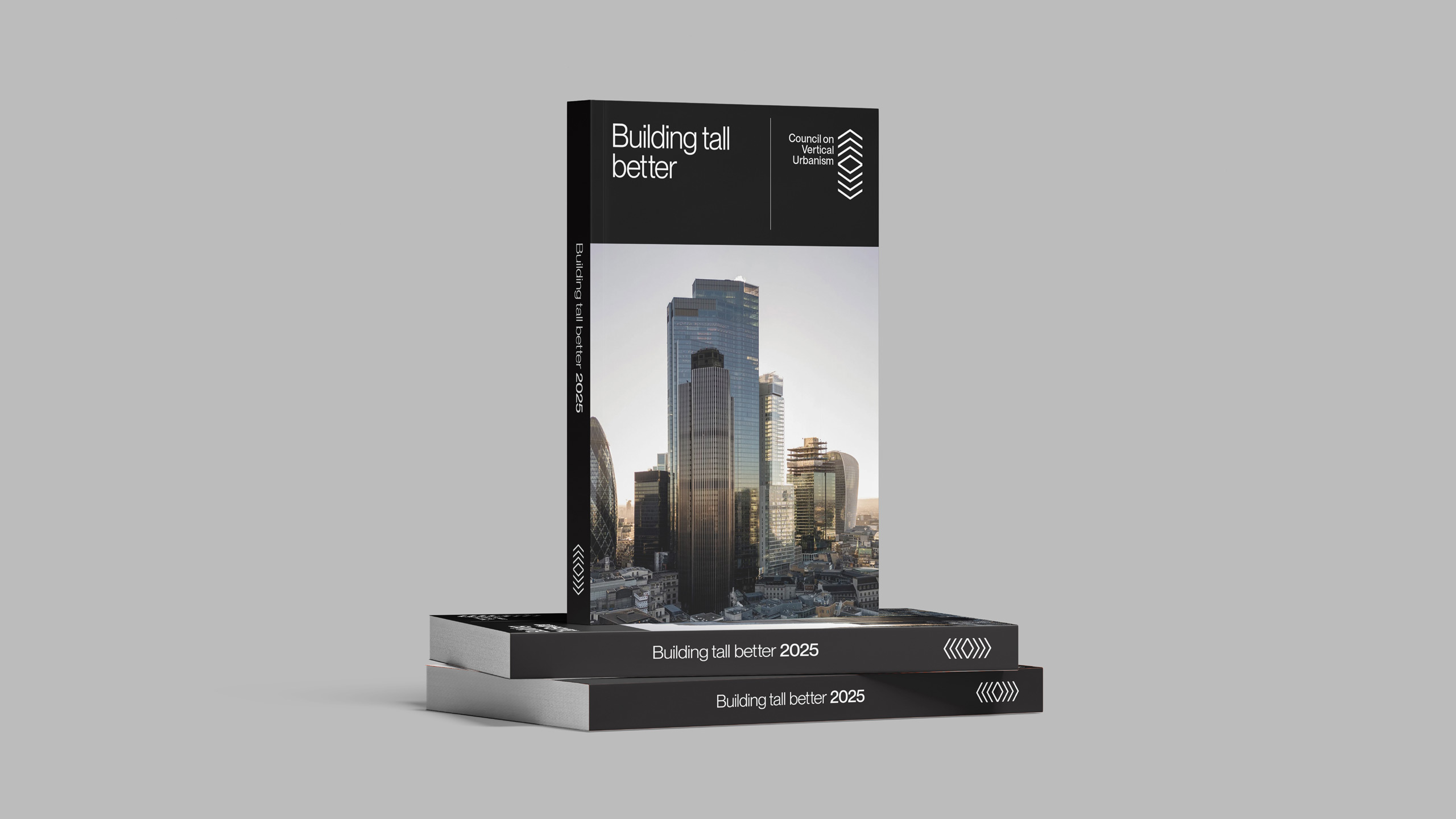 Building Tall Better’ book by the Council on Vertical Urbanism featuring a modern city skyline, displayed on stacked 2025 editions.