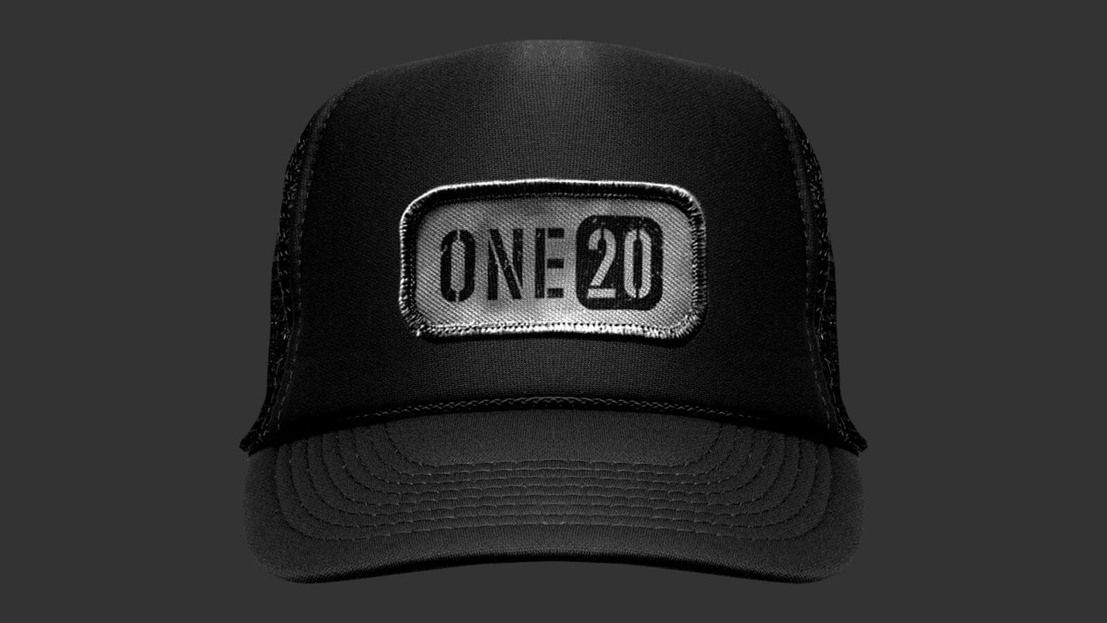 A black trucker hat with a mesh back features a silver patch on the front, displaying the text "ONE20" in bold, stylish letters, set against a dark background.